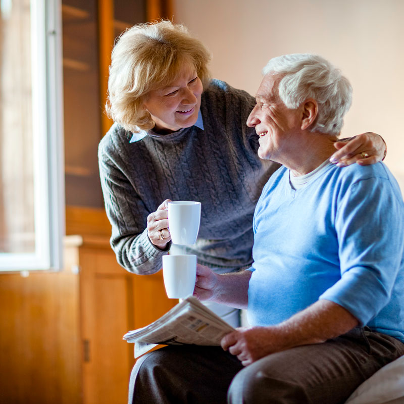 Staff member offering water to a senior man with dementia